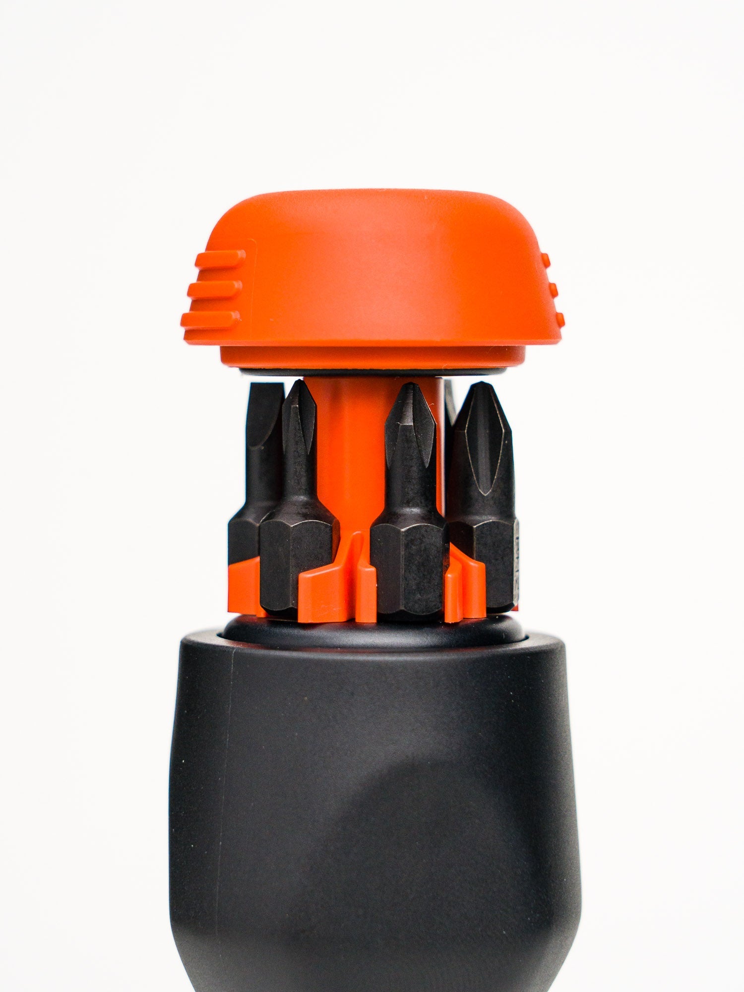Opened bit storage of black and orange stubby screwdriver